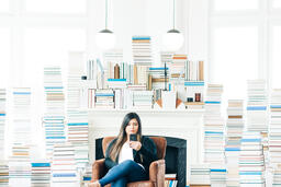 Woman Studying on an iPhone in a Living Room Full of Books  image 3