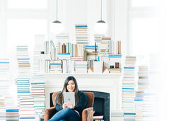 Woman Studying on an iPad in a Living Room Full of Books  image 3