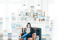 Woman Studying on an iPad in a Living Room Full of Books  image 2