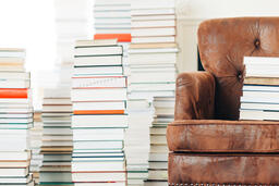 A Stack of Books on a Chair Surrounded by Books  image 5
