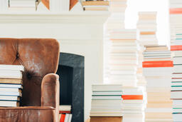 A Stack of Books on a Chair Surrounded by Books  image 1