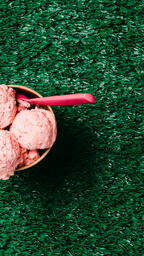 Carton of Strawberry Ice Cream with a Spoon on Grass  image 1
