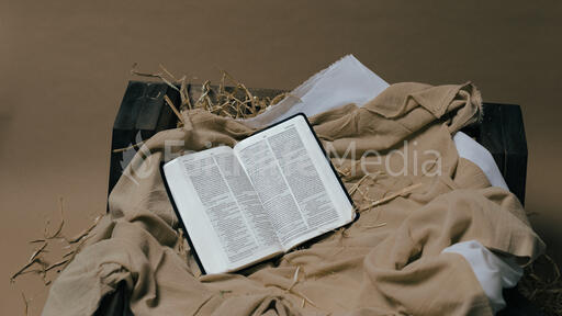 Bible Open to the Christmas Story in a Manger