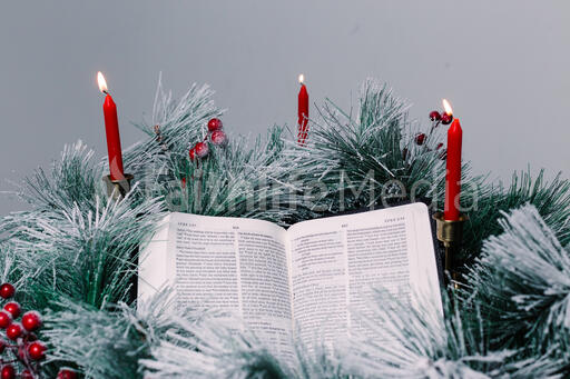 Bible Open to the Christmas Story with Greenery and Candles
