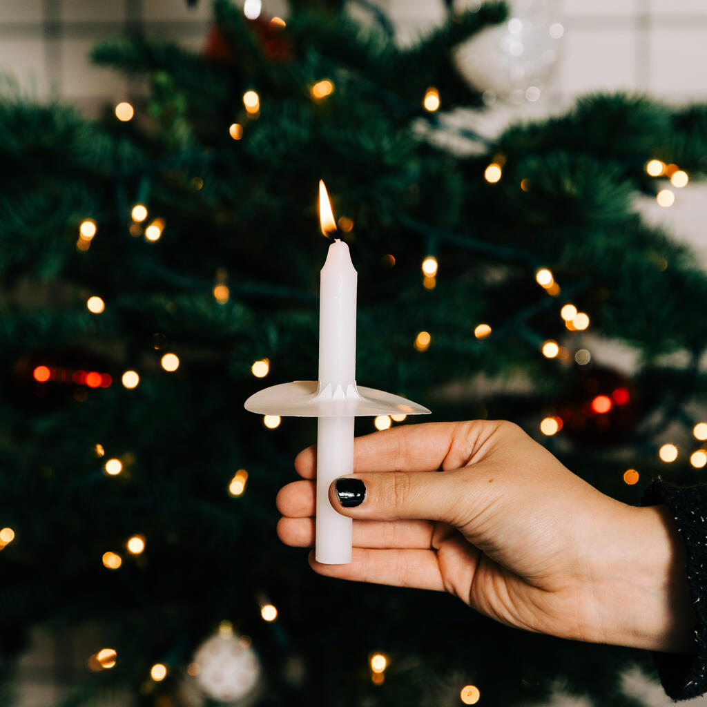 Hand in Frame Holding a Candle in Front of the Christmas Tree large preview