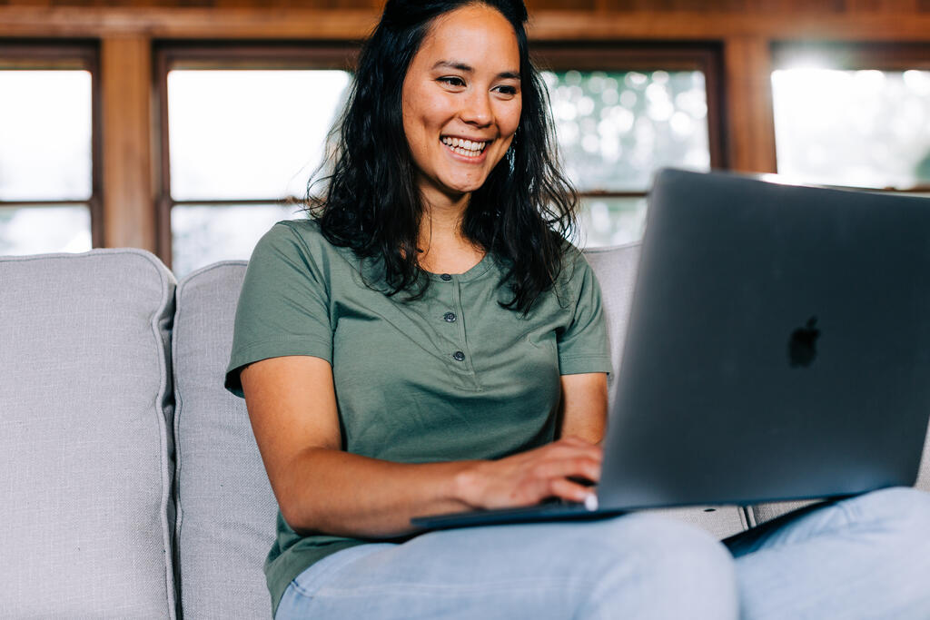 Woman Working on a Laptop and Smiling large preview