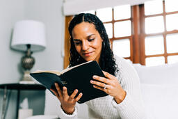 Woman Reading the Bible in Bed at Sunrise  image 1