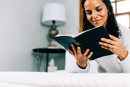 Woman Reading the Bible in Bed at Sunrise  image 2