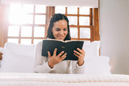 Woman Reading the Bible in Bed at Sunrise  image 2