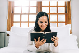 Woman Reading the Bible in Bed at Sunrise  image 2