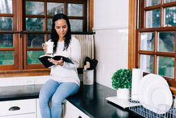 Woman Reading the Bible and Drinking Coffee in the Kitchen  image 3