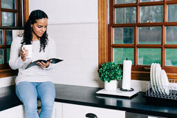 Woman Reading the Bible and Drinking Coffee in the Kitchen  image 4