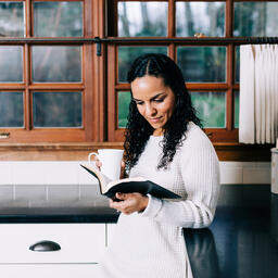 Woman Reading the Bible and Drinking Coffee in the Kitchen  image 3