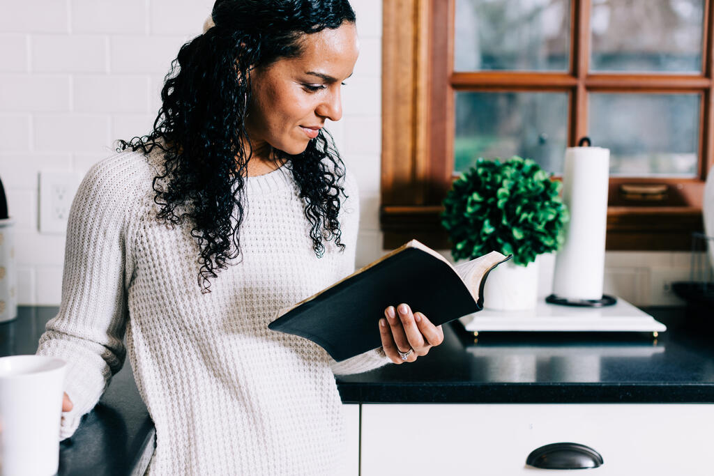 Woman Reading the Bible and Drinking Coffee in the Kitchen large preview