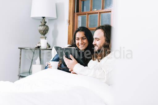 Husband and Wife Reading the Bible Together in Bed