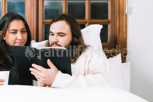 Husband and Wife Reading the Bible Together in Bed