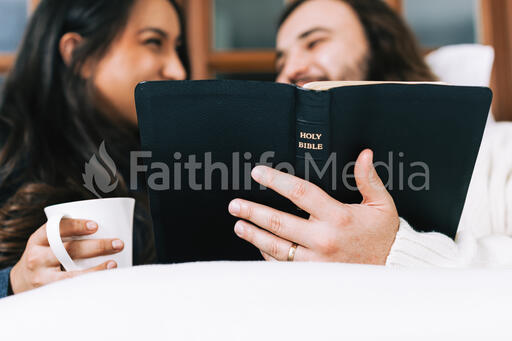 Husband and Wife Reading the Bible Together in Bed