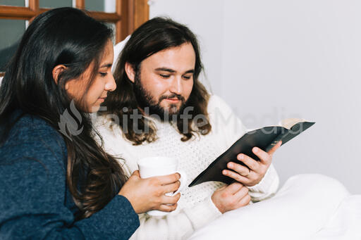 Husband and Wife Reading the Bible Together in Bed