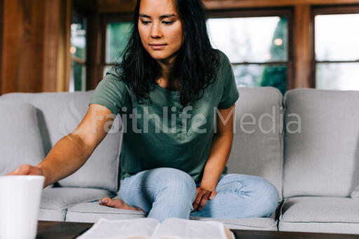 Woman Grabbing Her Cup of Coffee During Devotions