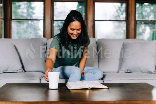 Woman Grabbing Her Cup of Coffee During Devotions