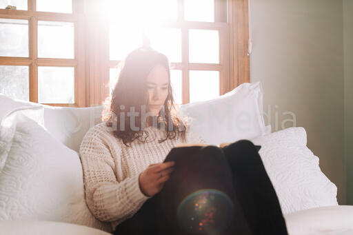 Woman Reading the Bible in Bed at Sunrise