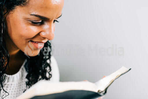 Woman Reading the Bible in Bed