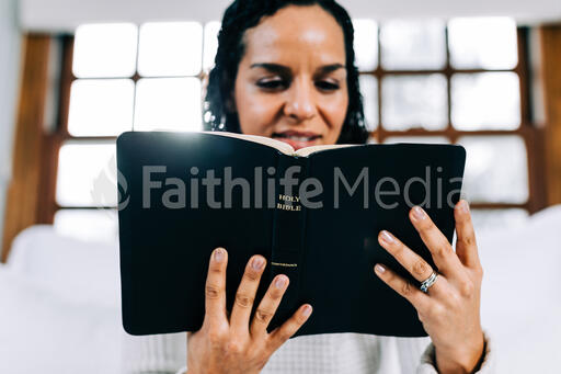 Woman Reading the Bible in Bed at Sunrise