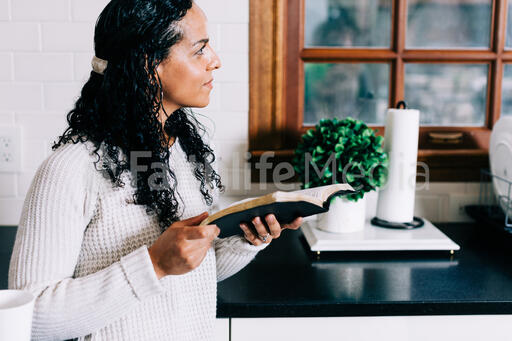 Woman Reading the Bible in the Kitchen
