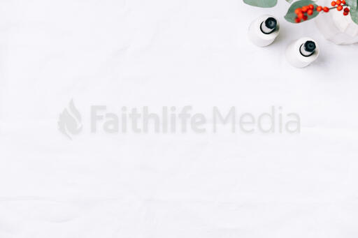 Christmas Florals and Taper Candles on a White Linen Tablecloth