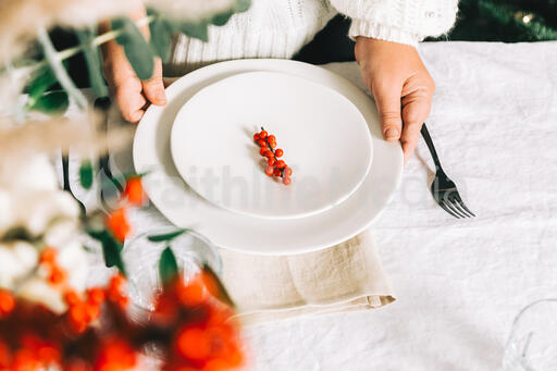 Woman Setting the Table for Christmas Dinner