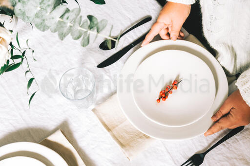 Woman Setting the Table for Christmas Dinner