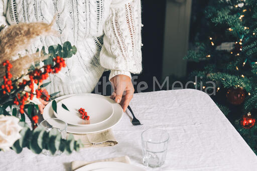 Woman Setting the Table for Christmas Dinner