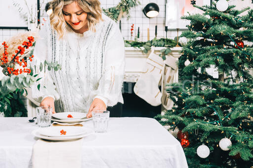 Woman Setting the Table for Christmas Dinner