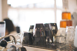 Cups Stacked on Top of an Espresso Machine  image 1