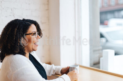 Woman Laughing with a Cup of Coffee