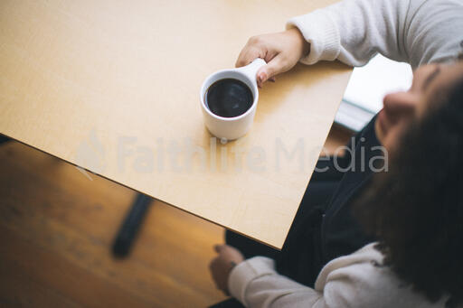 Woman at a Table with a Cup of Coffee