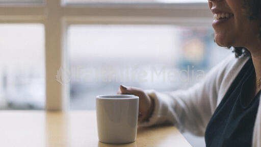 Woman Laughing with a Cup of Coffee