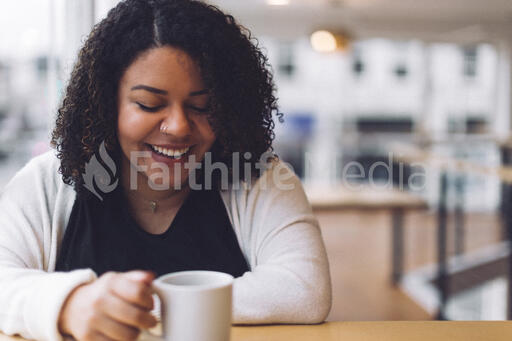 Woman Laughing with a Cup of Coffee