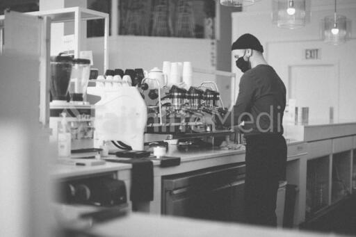 Barista Wearing a Mask and Making Coffee