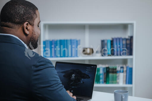 Looking Over Shoulder of Man Working on Laptop