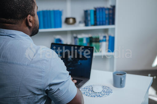 Looking Over Shoulder of Man Working on Laptop