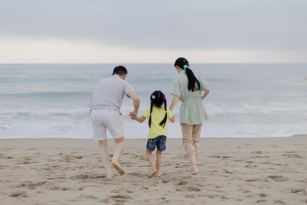 Family Walking Together Toward the Ocean Shore large preview