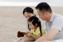 Family Reading the Bible Together on the Beach  image 2