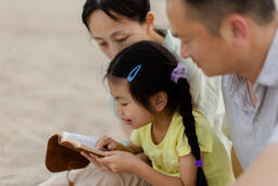 Family Reading the Bible Together on the Beach  image 1