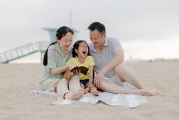Family Reading the Bible Together on the Beach  image 3