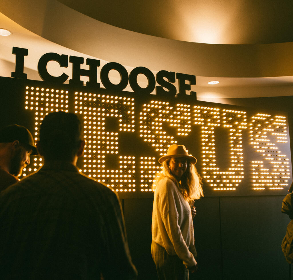 Woman Walking In Front of Lit Up I Choose Jesus Sign large preview