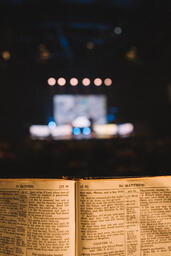 Bible Open to the Book of Matthew with Stage Lights Behind  image 1