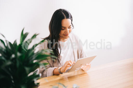 Woman Working on an iPad at a Desk