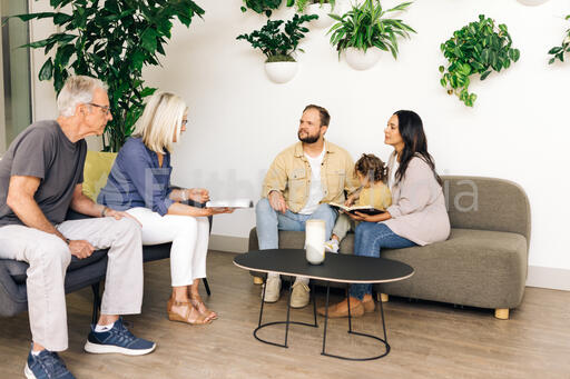 Young Family Reading the Bible with an Older Couple