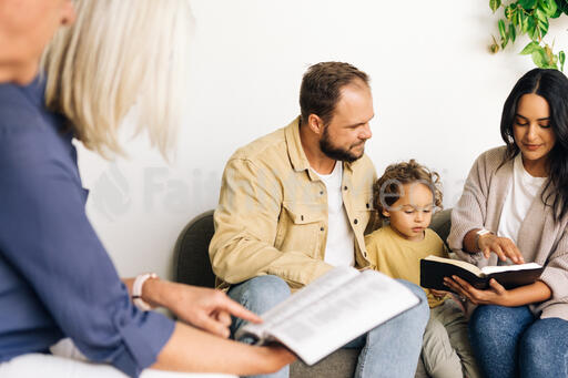 Young Family Reading the Bible with an Older Couple